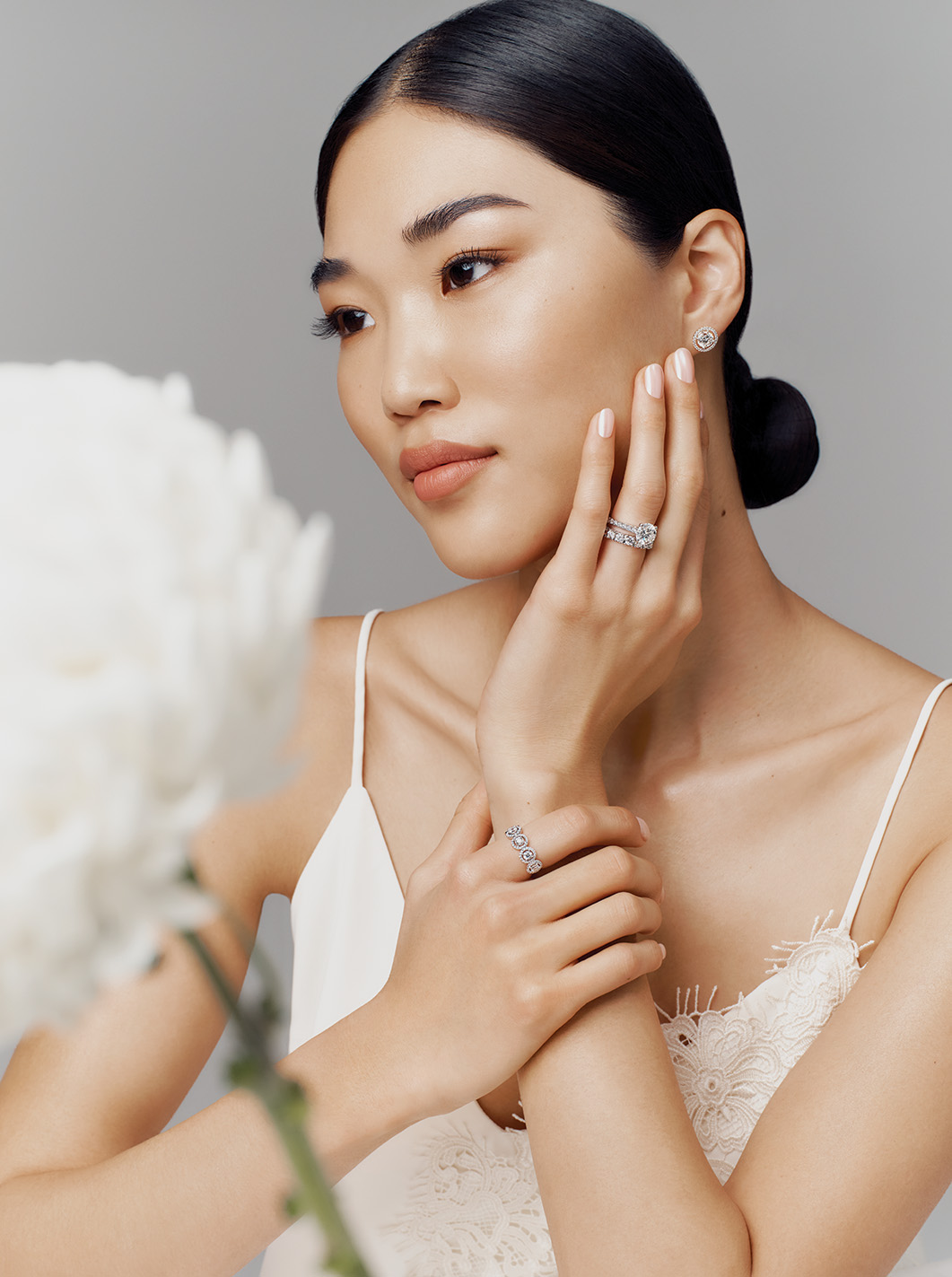 A model wears diamond rings and a cream lace blouse