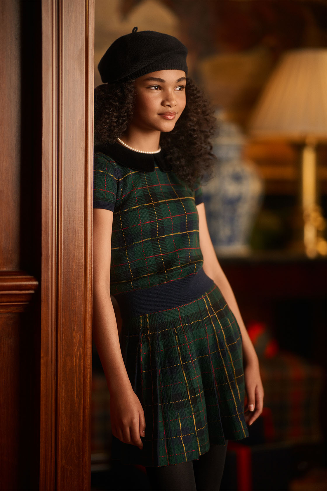 Girl wearing Ralph Lauren green and black tartan dress, with a black beret