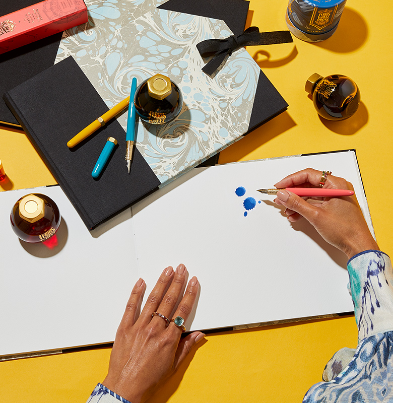 Overhead shot of woman hands drawing using ink pens