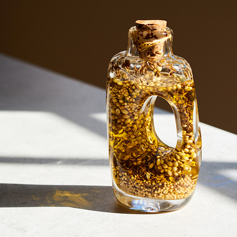 Olive oil sitting on a table with light shining through it