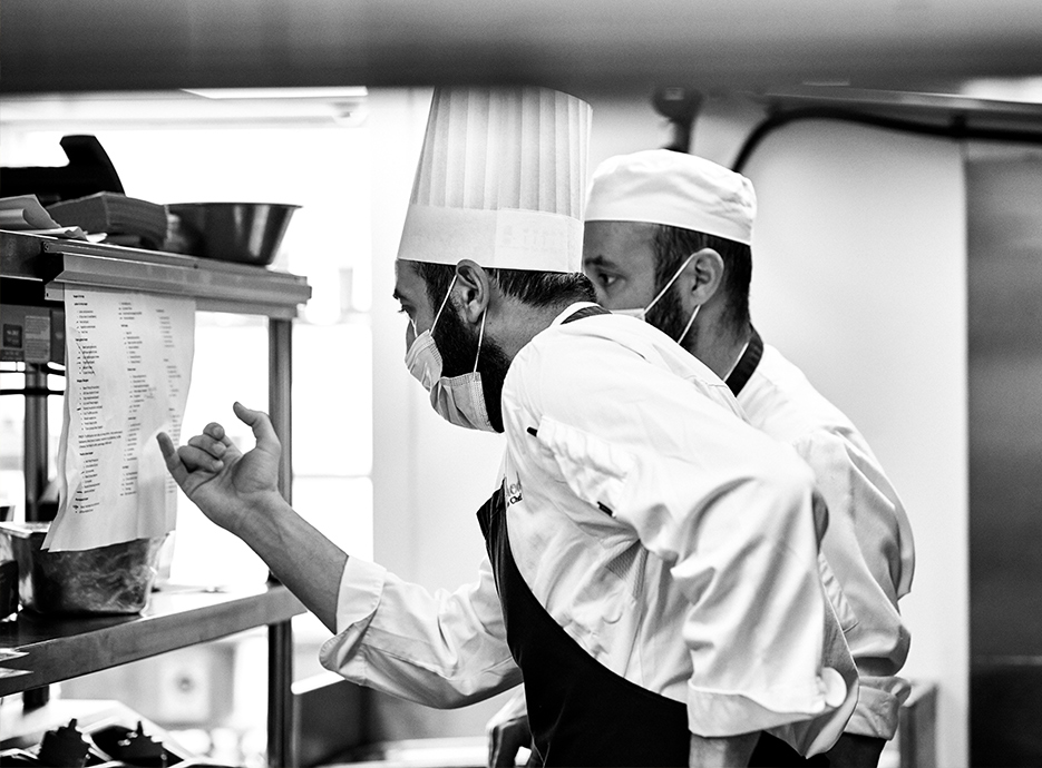 Chefs looking at menu in the kitchen