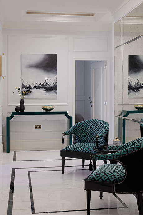 Seating area with green seats by large glass mirror wall