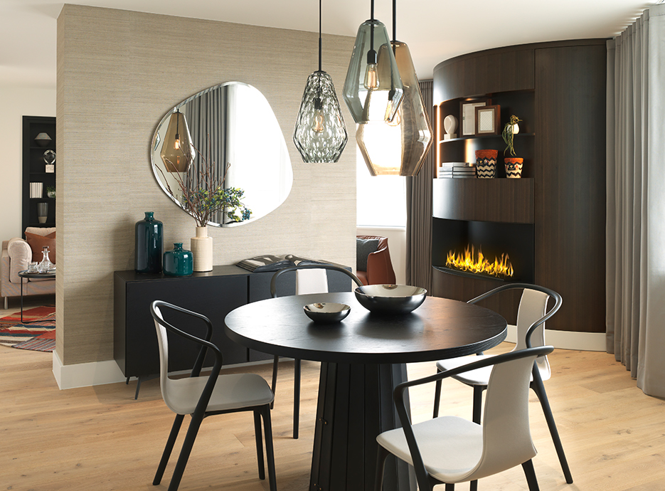 Dining room setting with large glass light fitting hanging from the ceiling and fireplace in background