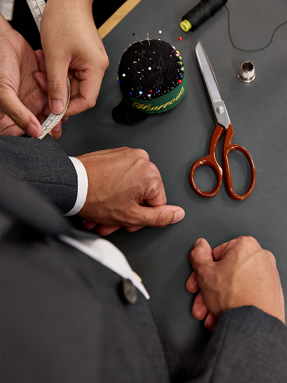 Tailor measuring a suit cuff