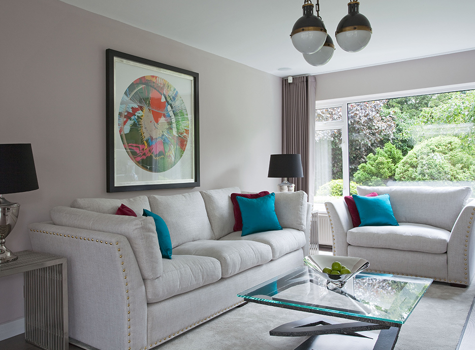 Living room area with large white sofas and glass coffee table