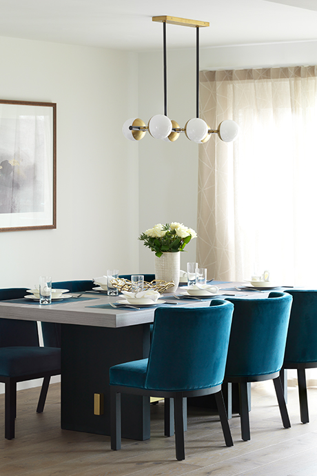 Dining table with large modern chandelier over the top