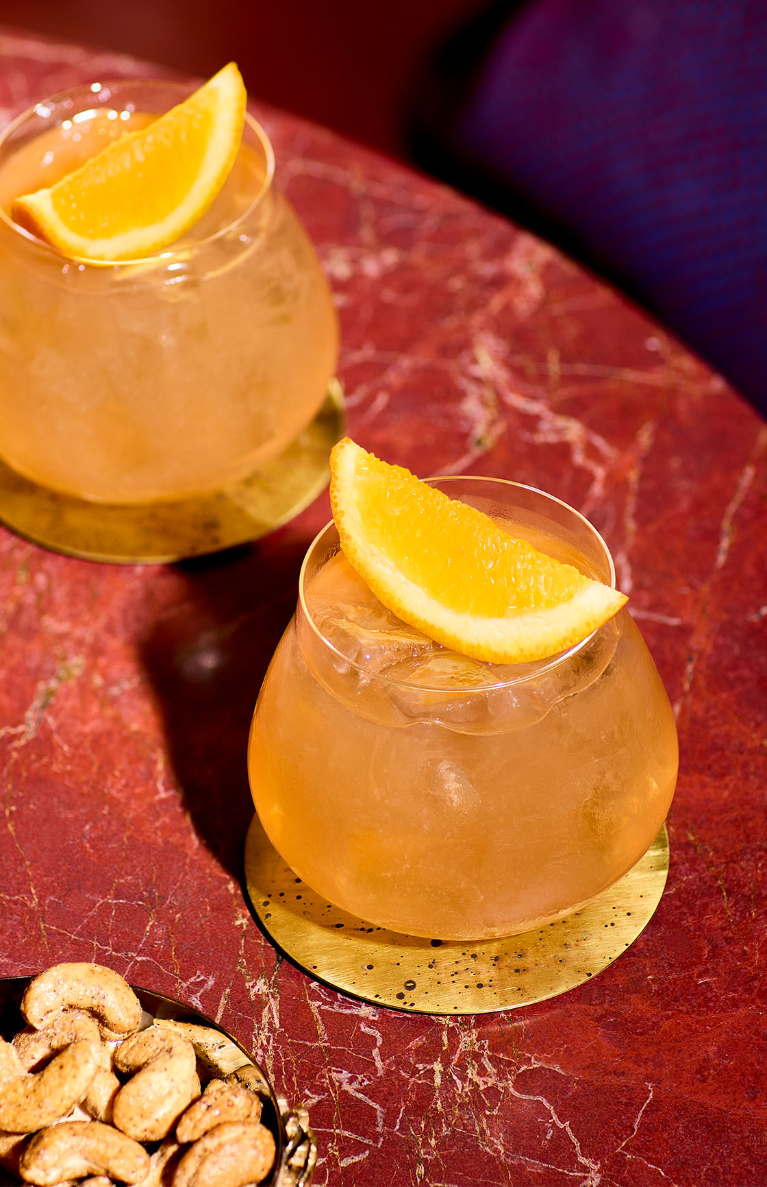 Small glass of Autumn Punch garnished with a lemon wedge