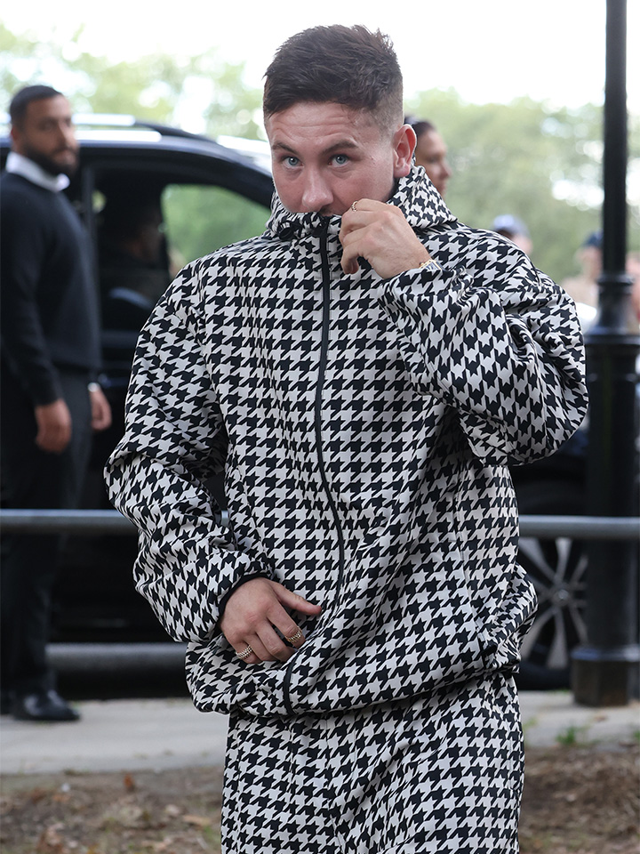 Wearing a monochrome houndstooth hoodie and sweatpants, Saltburn actor Barry Keoghan attends the Burberry Spring/Summer 2024 runway at London Fashion Week