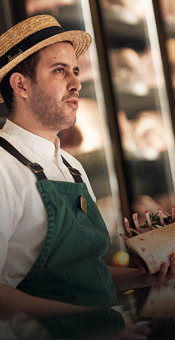 In house butcher showing a customer a recommended cut of meat