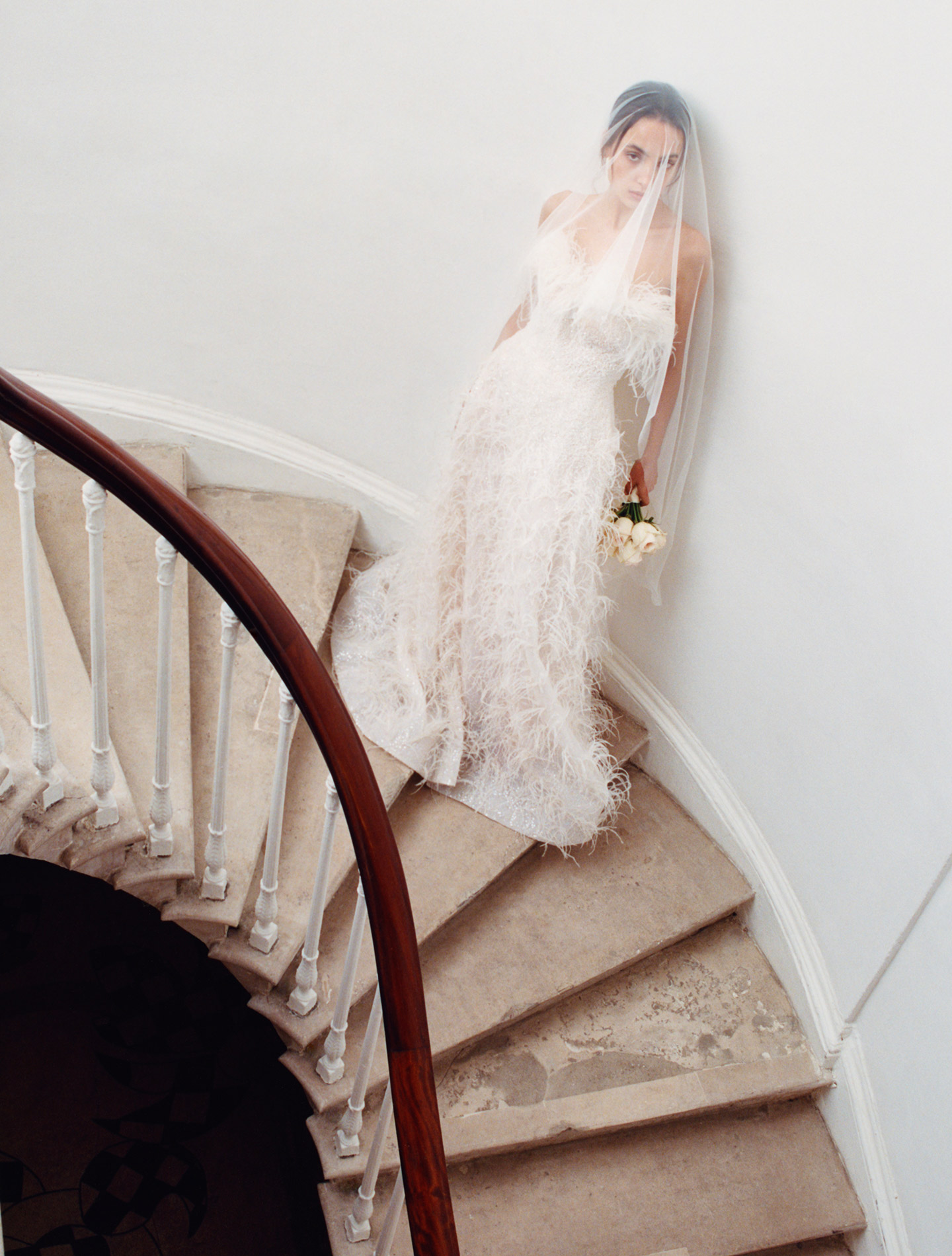 Bride wearing on stairs wearing fur wedding dress