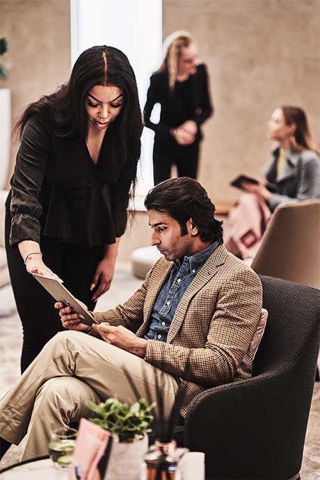 Receptionist showing man item on Treatment Menu at the Wellness Clinic at Harrods