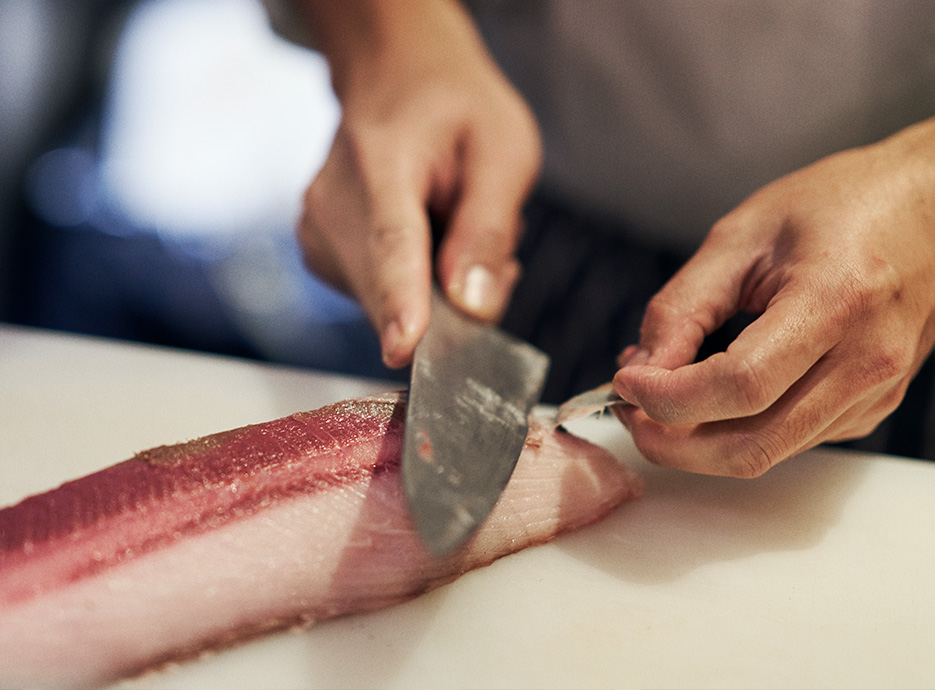 Chef preparing fish for a dish at Chai Wu a Harrods Restaurant