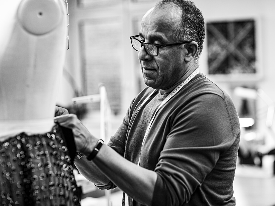 Man fitting a dress to a mannequin