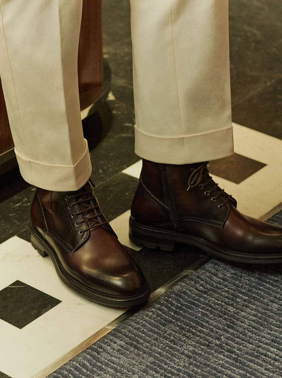 Brown Chelsea boots matched with a cream suit