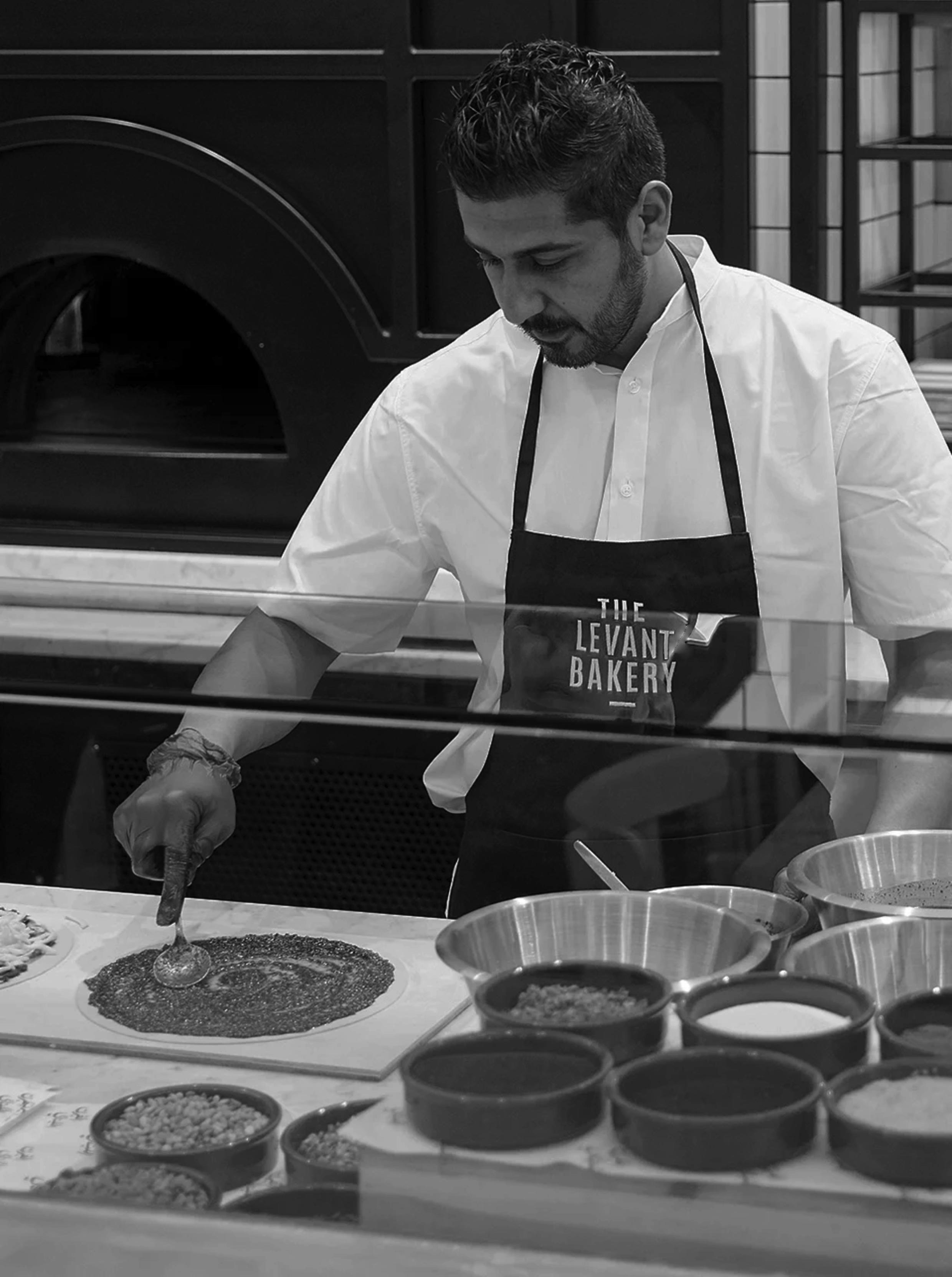 Chef putting pesto on flatbread