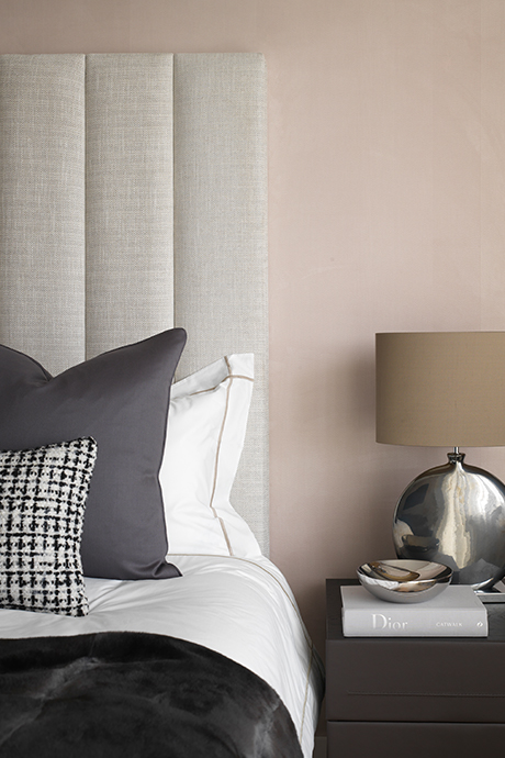 Side table of bedroom in grey muted tones and blush pink wall