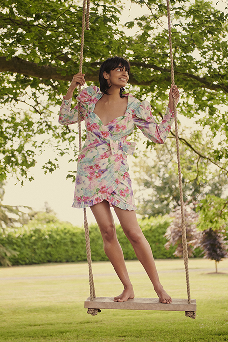 Ameera in pink Alessandra Rich dress standing on a swing