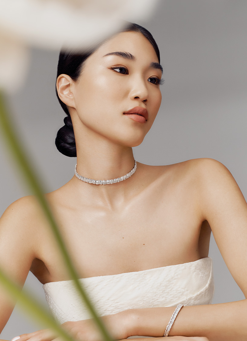 A model wears a Suzanne Kalan diamond choker necklace with a strapless white bridal dress by Emilia Wickstead