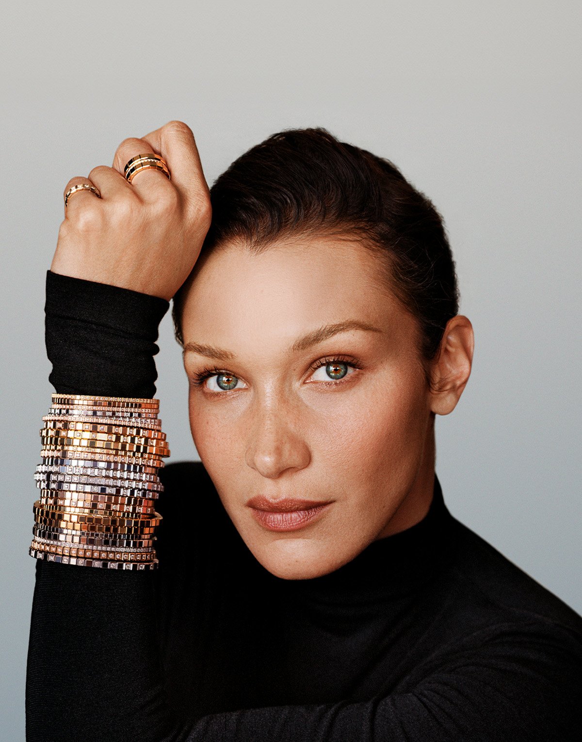 Hand wearing Chopard watch and bracelets, being held by another hand wearing Chopard rings