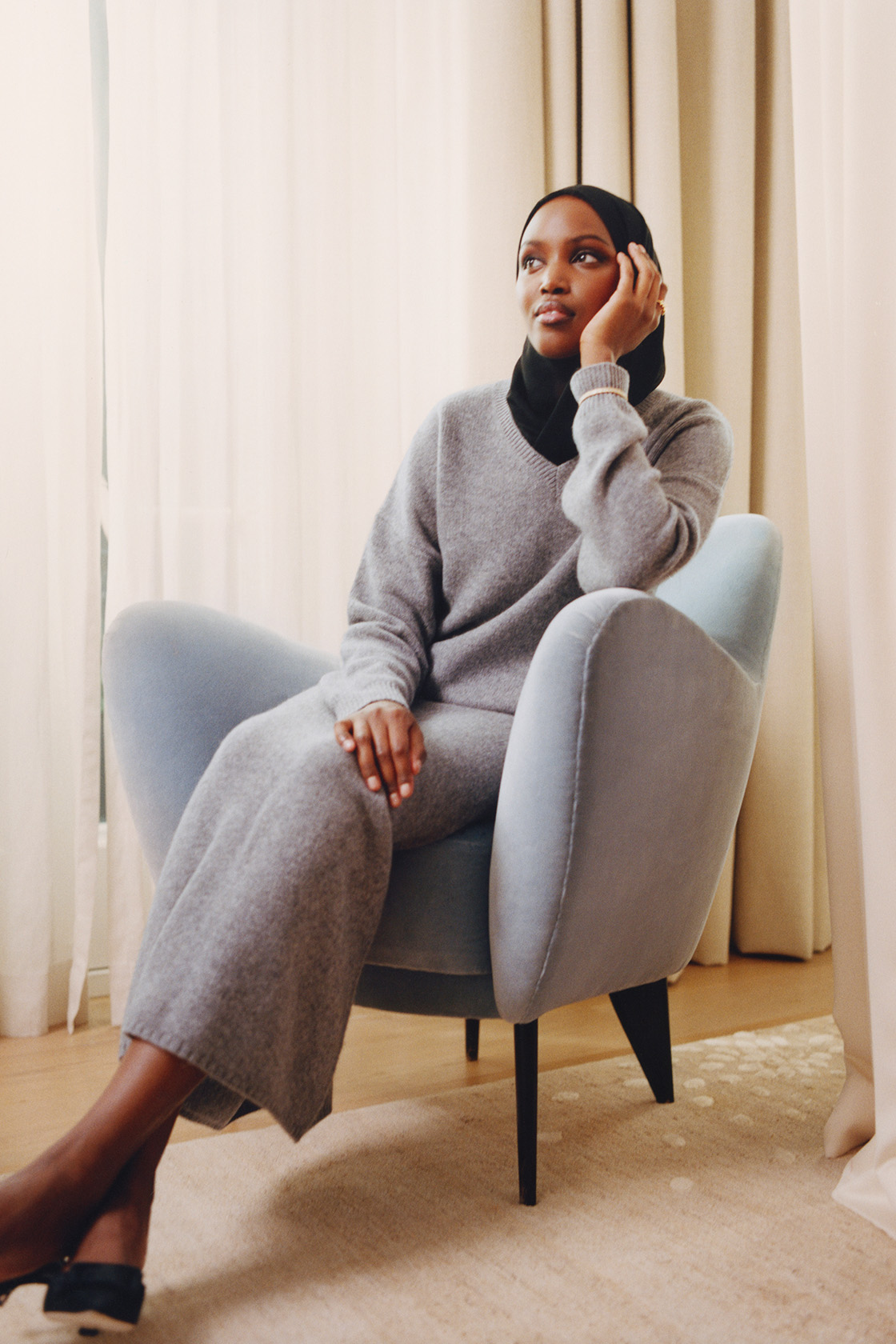 Woman wearing grey knitwear and black headscarf