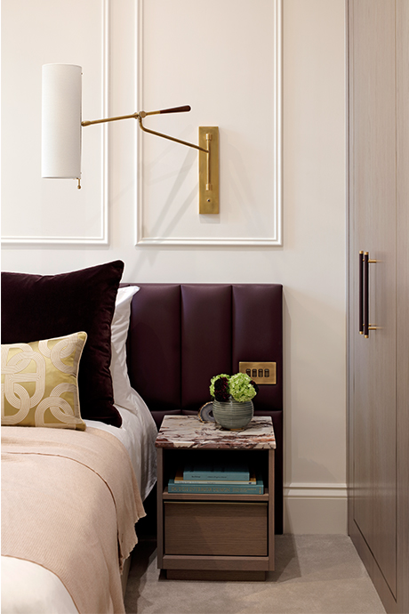 Side table of bedroom with large wall lamp