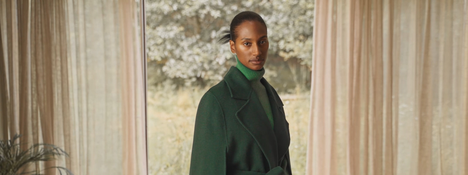 Woman wearing a black puffer jacket and red Jil Sander scarf