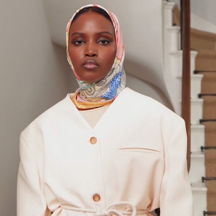 Woman in white jacket and multicoloured headscarf