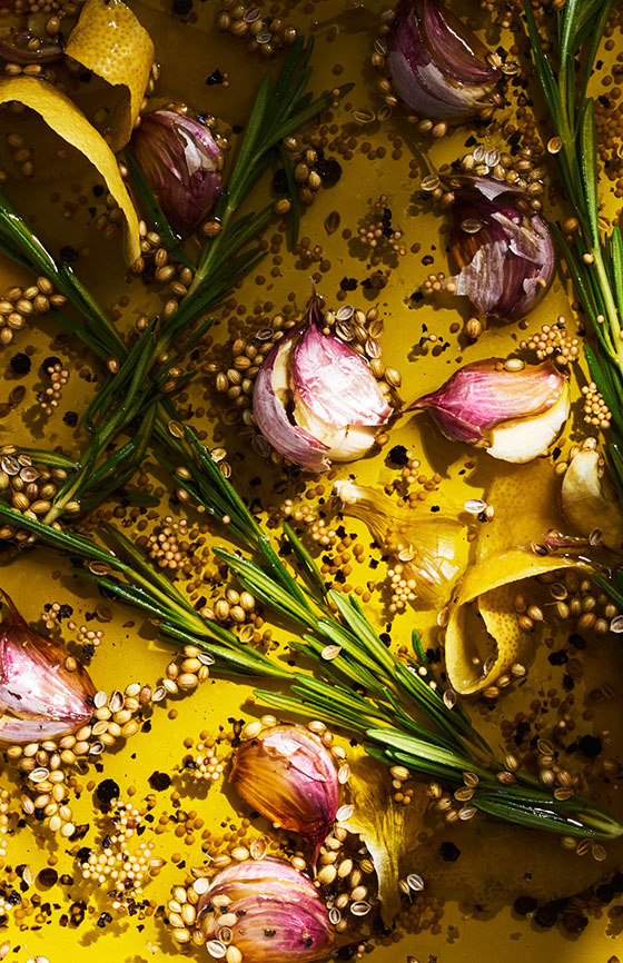 Detail of garlic and thyme being roasted in a pan