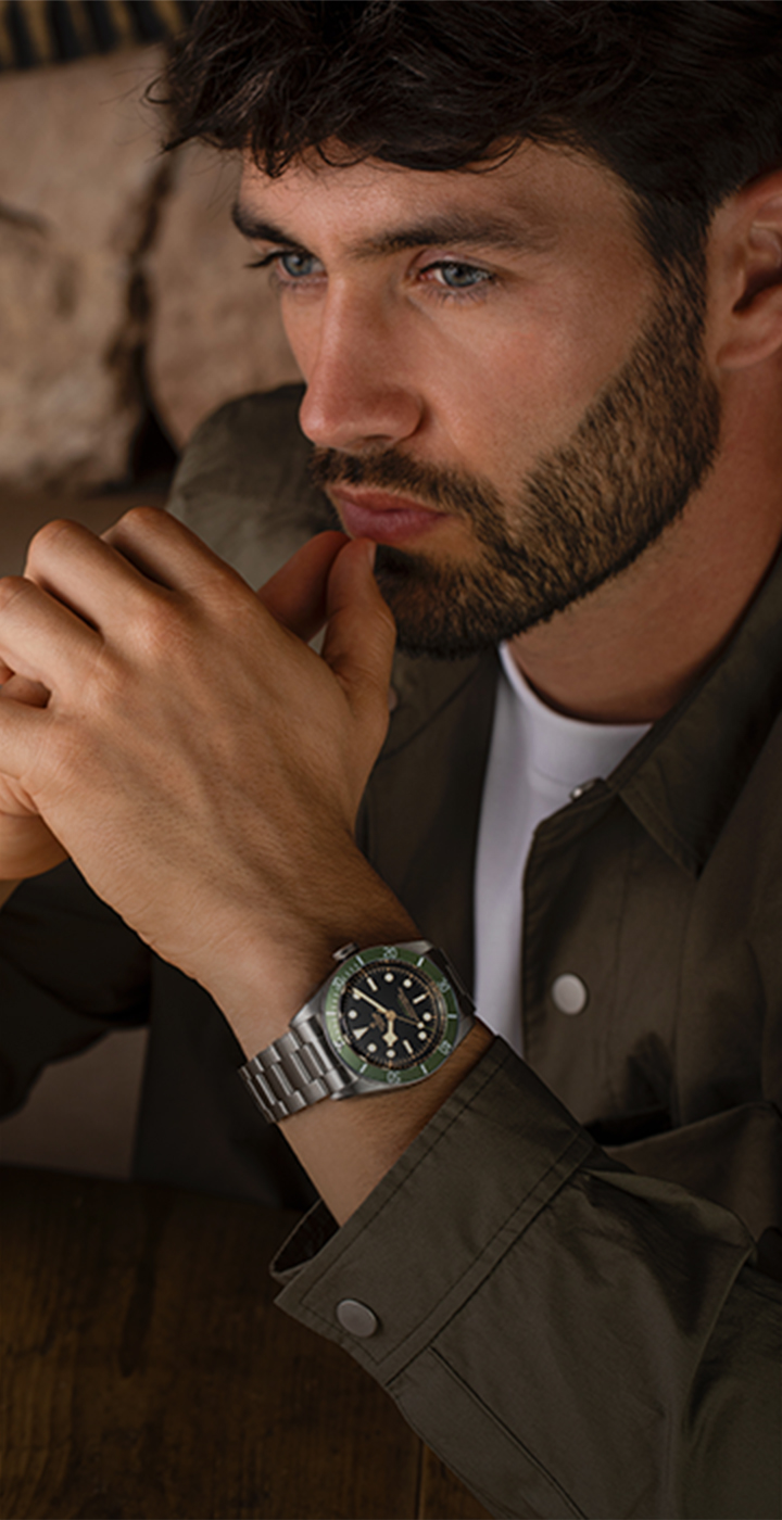 Harrods employee helping a customer try on a Tudor watch in the boutique in-store