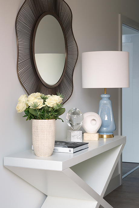 Sideboard in the hallway with lamp, flowers and mirror