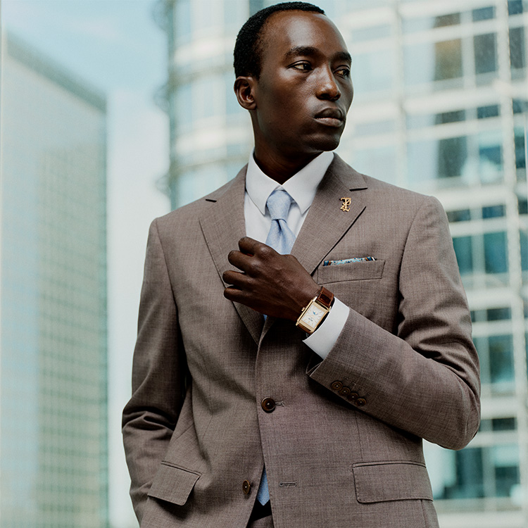 Male model wears grey suit and Jaeger-LeCoultre Reverso watch