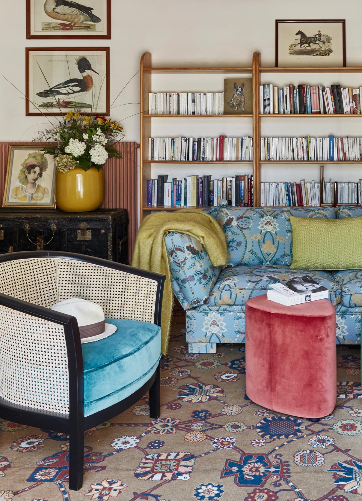 Living room setting in Pierre Frey's house with sofa, armchair and bookcase