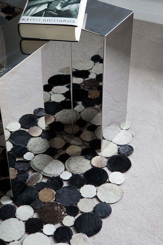 Mirrored coffee table on top of spotted rug