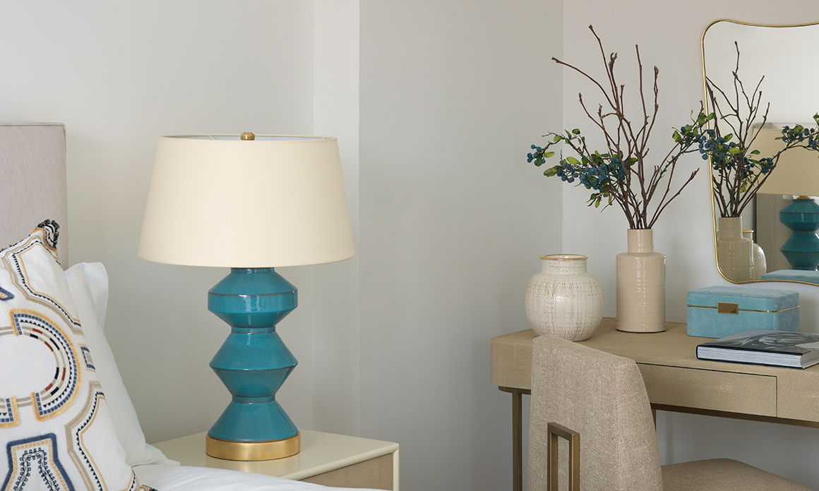 Side table in guest bedroom with turquoise lamp