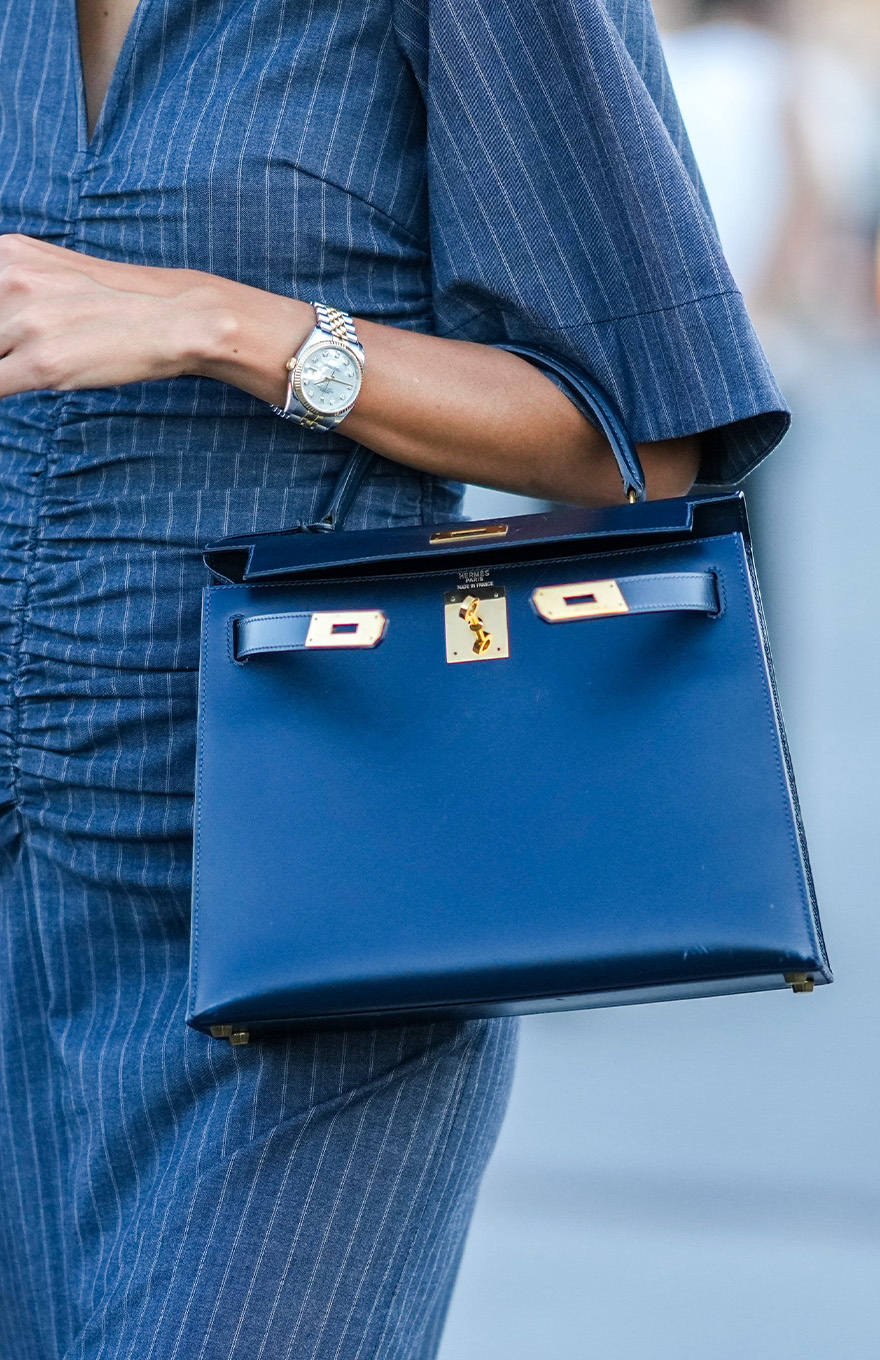 Hand holding blue Fendi bag