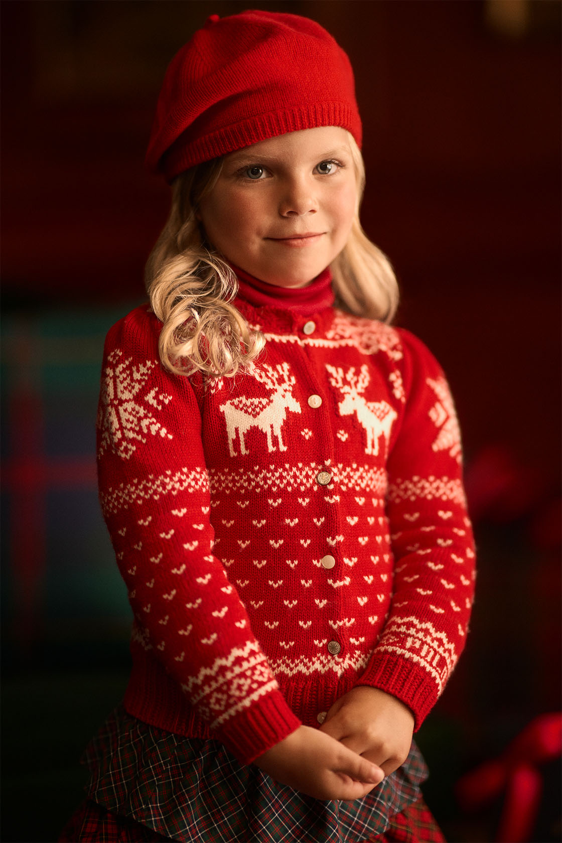 Girl wearing a red knitted Ralph Lauren Christmas jumper and red hat