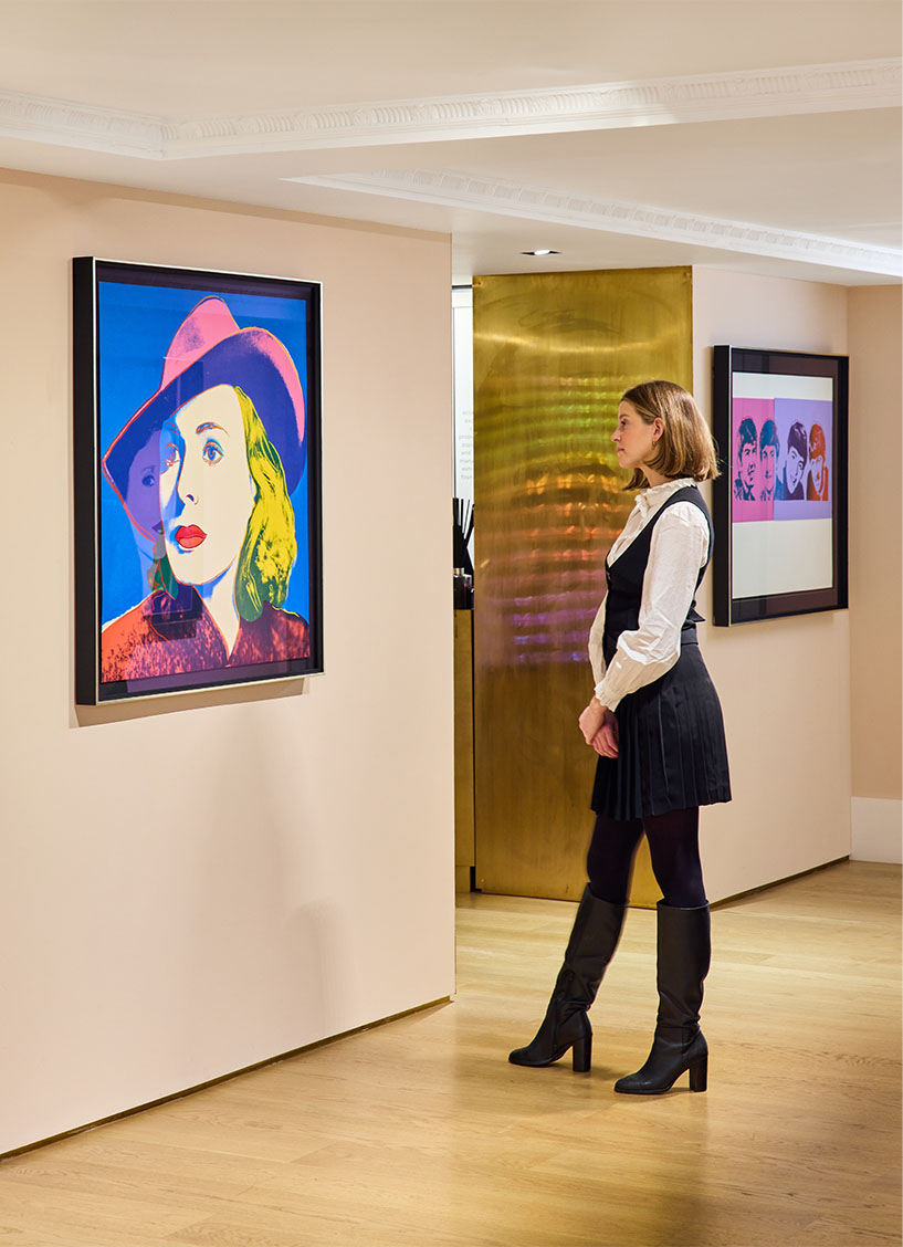 Woman looking at an Andy Warhol picture on the wall of the Halcyon Gallery