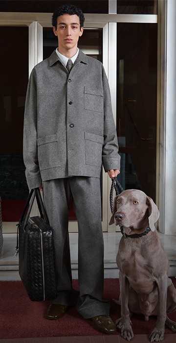 Model holding a Bottega Veneta chocolate brown, padded clutch