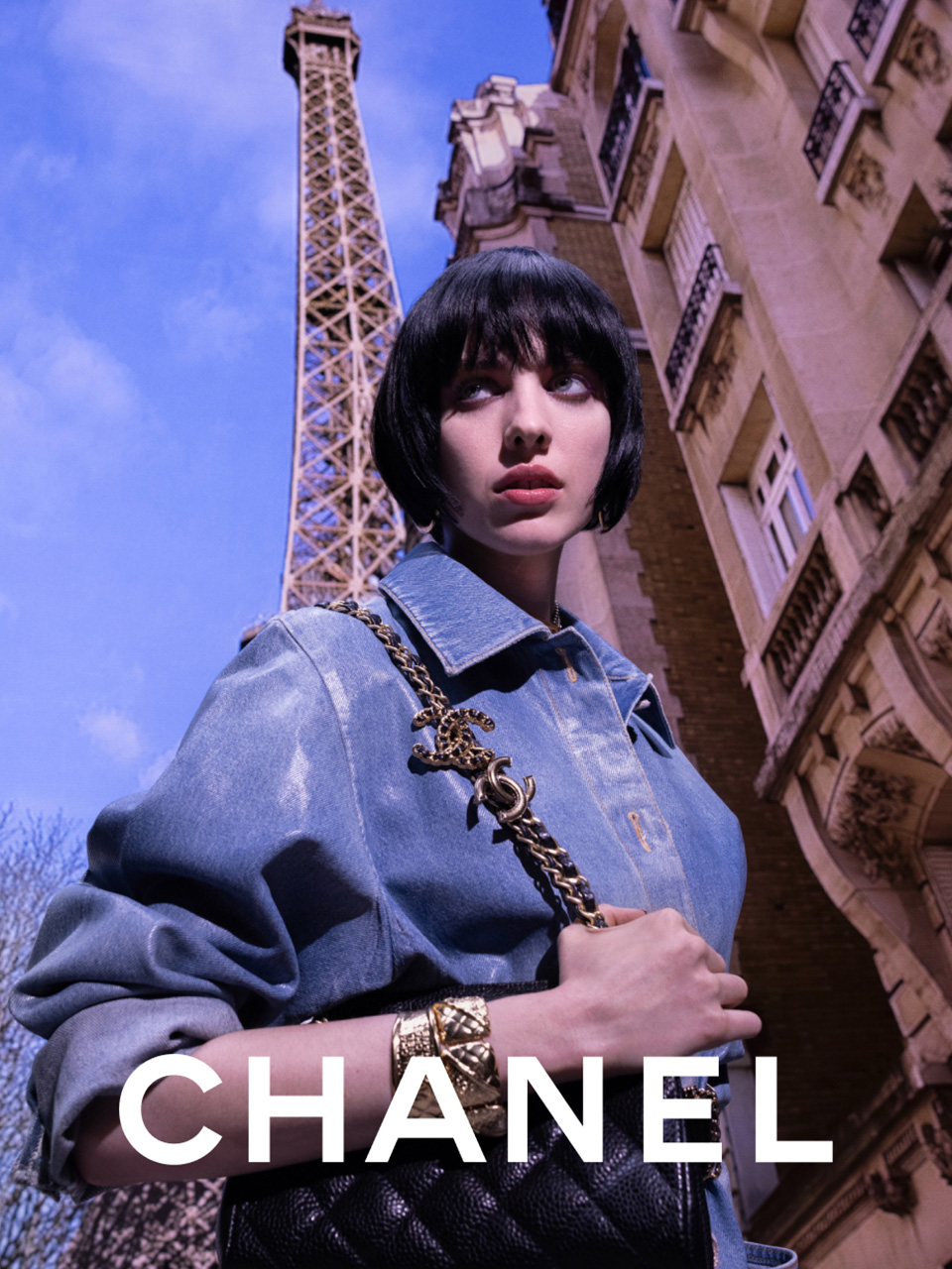 Woman wearing a CHANEL denim jacket under the Eiffel Tower