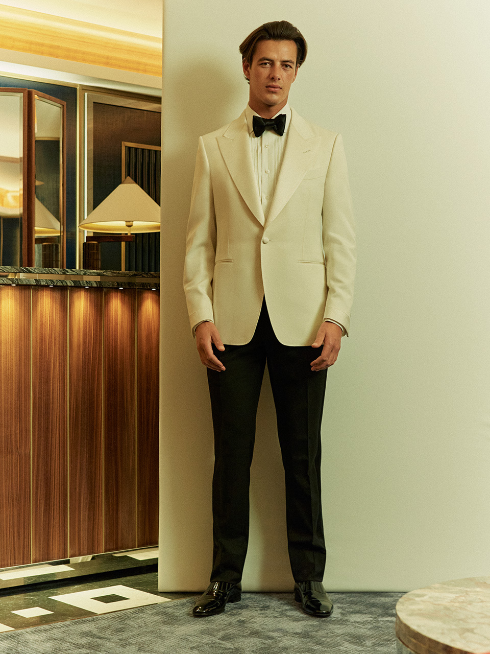 Man wears cream tuxedo with black bow-tie