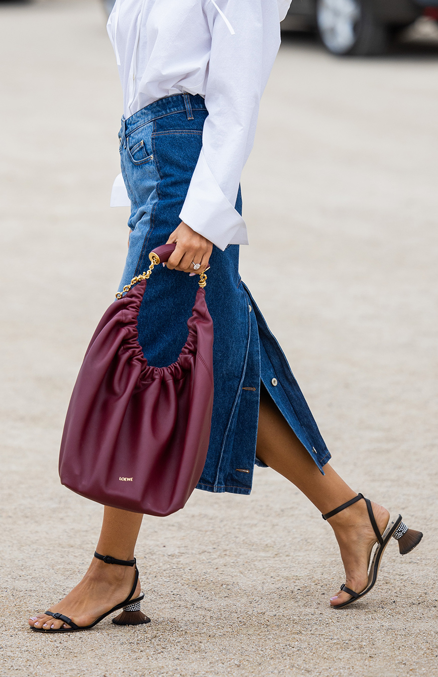 Woman holding slouchy purple Loewe Squeeze bag